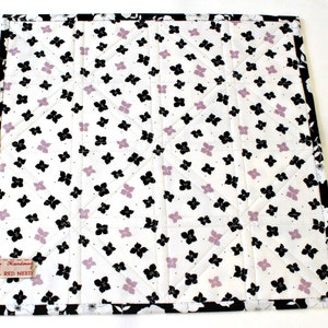 One layer cotton batting is sandwiched between the front and back. The back features black and lavender flowers on white. Black and white floral binding is handsewn to the back for a neat finish.