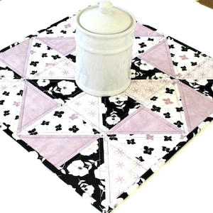 Quilted Floral Table Topper featuring flowers in black and lavender set on white and white flowers on black made in pinwheel design.