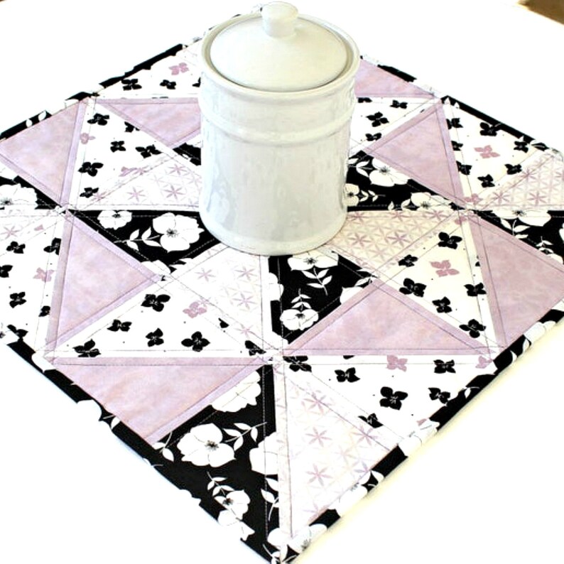 Quilted Floral Table Topper featuring flowers in black and lavender set on white and white flowers on black made in pinwheel design.