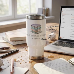 Può includere: Tazza da viaggio bianca con bordo e base argentati, con grafica di pila di libri. Il testo sulla tazza recita "Writing for Substack, One Refill at a Time, author". Un laptop e materiale di scrittura sono su una scrivania di legno.