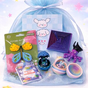 May include: A collection of colorful toys and small items, including a butterfly toy, a miniature book, and an octopus figurine, presented in a blue drawstring bag. The background features a sky-themed design with stars.