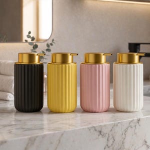 May include: A set of three ceramic mugs with a speckled, matte finish. The mugs are in shades of cream, light grey, and dark grey. Each mug has a simple, minimalist design, ideal for coffee or tea.