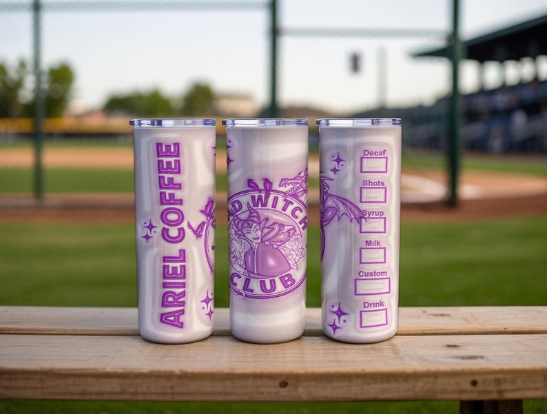 May include: Three white insulated tumblers with purple graphics and text. One tumbler reads "ARIEL COFFEE" vertically. The center tumbler features a witch design and the words "BAD WITCH CLUB". The third tumbler has a coffee order form.