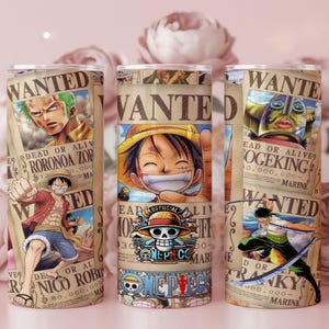 Puede incluir: Tres vasos de acero inoxidable presentan carteles de "Se Busca" con personajes de anime. Los carteles son de color beige con texto negro e ilustraciones de personajes como Luffy, Zoro y Franky. Los vasos tienen un borde y una base plateados, y el logo de One Piece.