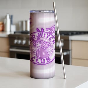 May include: A tall, purple tumbler with a stainless steel straw. The tumbler features a circular design with the words "BAD WITCH CLUB" and a graphic of a witch. The background has a gradient effect.