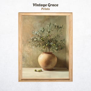 May include: A framed print featuring a still life of an olive branch in a terracotta vase. The artwork has a vintage aesthetic, with the text "Vintage Grace Prints" at the top. Several green olives are scattered near the vase.