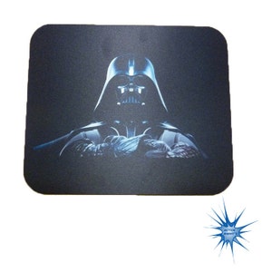 May include: Black mouse pad with a dark blue image of Darth Vader from Star Wars.
