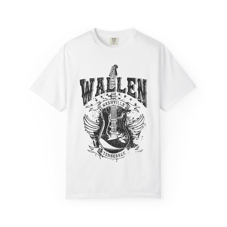 May include: White t-shirt featuring a distressed black graphic of an electric guitar with wings, the word "WALLEN" above, and "NASHVILLE TENNESSEE" below. The shirt is a classic crew neck style.