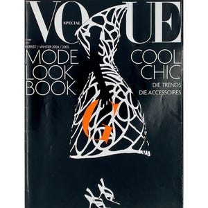 May include: Vogue magazine cover featuring a black background with white and orange text and graphics. The cover includes the text "Vogue Special", "Mode Look Book", and "Cool Chic". A graphic of a dress is in the center.