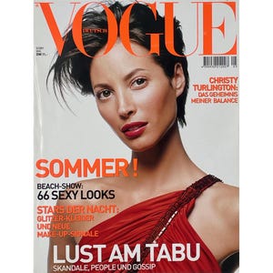 Könnte beinhalten: Ein Magazin-Cover mit einer Frau mit dunklem Haar und rotem Lippenstift. Das Wort "VOGUE" steht oben in Orange. Das Cover enthält den Text "SOMMER!" und "66 SEXY LOOKS".