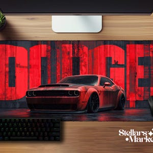 May include: A large rectangular mouse pad featuring a red Dodge muscle car illustration. The word "DODGE" is in large red letters on a dark background. A black keyboard and mouse are also visible.