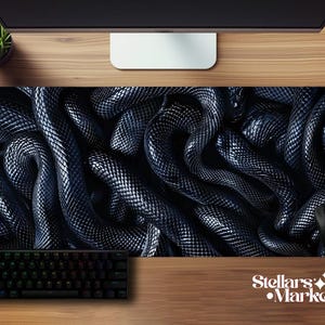 May include: A black and silver mouse mat with a detailed pattern of intertwined snakes. The mat is rectangular and includes a keyboard and mouse, with the Stellar's Market logo in the bottom right corner.