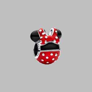 Puede incluir: Un charm rojo con lunares blancos, orejas negras y un lazo a juego. El charm es una representaci&oacute;n estilizada de un famoso personaje de dibujos animados. La palabra "PANDORA" est&aacute; grabada en el lateral.