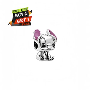 May include: A silver-colored charm featuring a cartoon character with large eyes, a small nose, and large ears with pink accents. The charm is in a sitting position. The image includes a banner that says "SPECIAL OFFER BUY 2 GET 1 FREE".