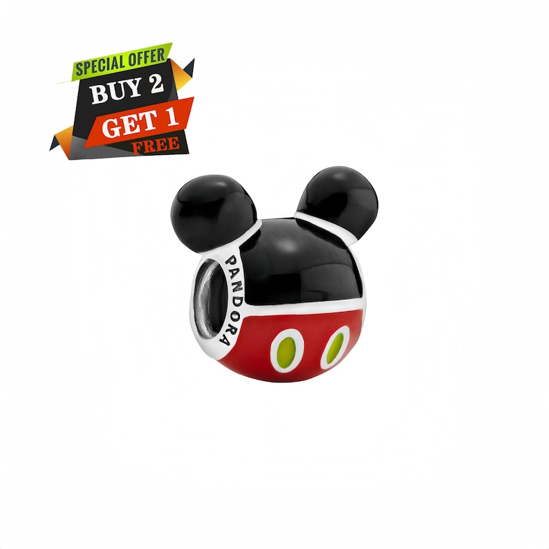 May include: A silver charm with a Mickey Mouse design. The charm features black ears, a black and red head, and two green ovals. The word "PANDORA" is printed on the charm. The image also includes a "BUY 2 GET 1 FREE" offer.