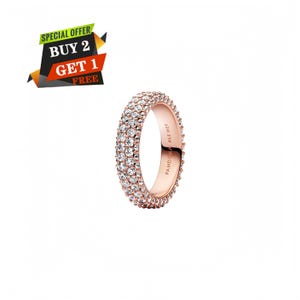 Pode incluir: Um anel em tom de ouro rosa com três filas de pedras transparentes de corte redondo cravadas em pavé na superfície exterior. O interior da banda tem gravado o texto PANDORA ALE MET. Um gráfico no canto superior esquerdo exibe SPECIAL OFFER BUY 2 GET 1 FREE.