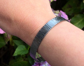 Brazalete grueso de plata de ley con textura martillada.