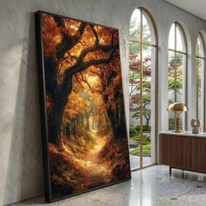 May include: A framed landscape art print depicts a vibrant autumn forest scene. The artwork showcases a path winding through trees with orange and red foliage. The print is leaning against a wall near a window.