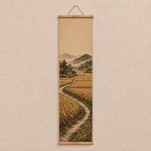 May include: A vertical wall hanging scroll featuring a sepia-toned landscape illustration of a winding dirt path through golden fields of grain, leading toward a small house nestled at the base of rolling mountains under a soft, hazy sky.
