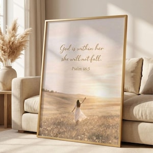 Op de afbeelding: Een ingelijste print met een gouden rand. De afbeelding toont een persoon in een witte jurk die door een veld loopt in de richting van de zonsondergang. De tekst luidt: "God is in haar, zij zal niet vallen. Psalm 46:5."