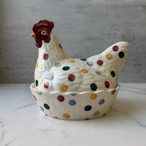 May include: A set of three ceramic mugs with a speckled, matte finish. The mugs are in shades of cream, light brown, and dark brown. Each mug has a simple, minimalist design, perfect for coffee or tea.