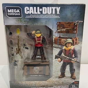 May include: A Mega Construx Call of Duty WWII Weapon Crate collector construction set. The box features two soldier figures, weapons, and a crate. The set includes 33 pieces and is for ages 10+. The box has text in English, French, and Spanish.