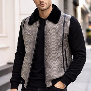 Puede incluir: Una elegante chaqueta con estampado de piel de serpiente en la parte delantera y cuello de piel negro. La chaqueta tiene mangas negras y cierre de cremallera. El modelo lleva vaqueros negros y una camiseta negra.
