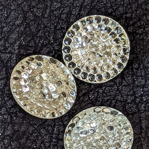 May include: Three clear glass buttons with a textured, raised, diamond-like pattern.