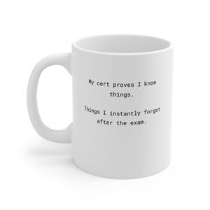Könnte beinhalten: Weißer Keramikbecher mit gebogenem Henkel. Der Becher trägt den Text: "My cert proves I know things. Things I instantly forgot after the exam." Der Becher ist für Heißgetränke konzipiert.
