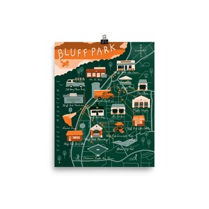 May include: A poster featuring a map of Bluff Park with illustrations of local businesses and landmarks. The map is in shades of green, brown, and orange, with the words "Bluff Park" at the top. The poster is held by a silver clip.