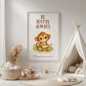 May include: A framed print featuring a cartoon monkey playing a drum, with the words "BE JOYFUL ALWAYS". The print is in a child's room, alongside a teepee and toys. The text "1 Thessalonians 5:16" is below the monkey illustration.