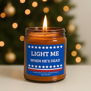 Amber glass candle jar featuring a patriotic blue and red label that says "Light Me When He's Dead" with white stars.