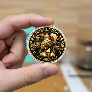 May include: A round, gold-colored coin with a white border, featuring the words "Black History" and the phrases "Honor, Heritage, Legacy." The coin's center depicts three figures, a map of Africa, and a building.