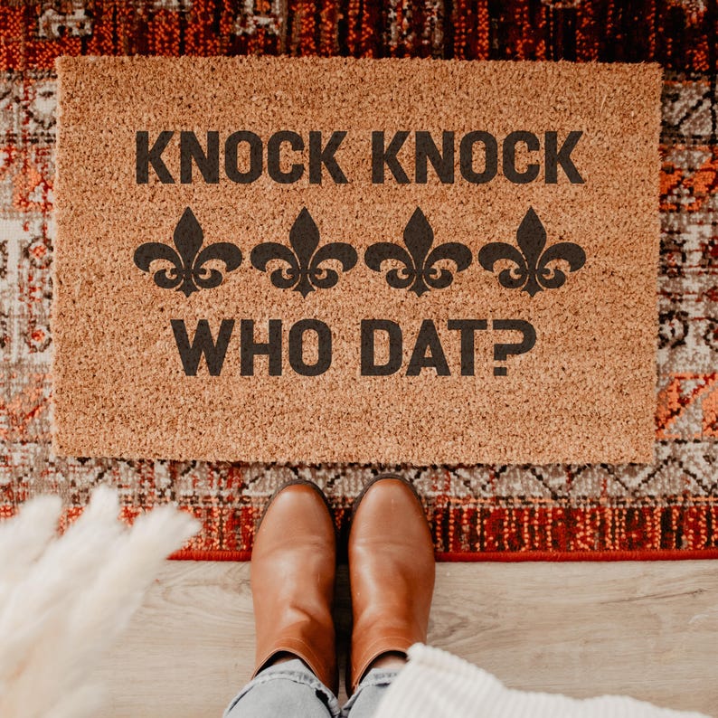 Funny football welcome mat featuring bold typography and fleur de lis symbols