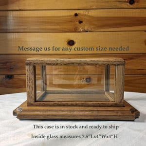 May include: A wooden display case with a rectangular glass enclosure. The case sits on a rectangular base. The text "Message us for any custom size needed" is visible. Inside glass measures 7.5"L x 4"W x 4"H.