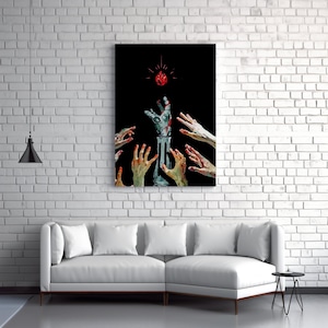 May include: A canvas print depicting a surreal scene. A mechanical arm reaches for a glowing red gem against a black backdrop. Several hands surround the arm, creating a dramatic composition. The artwork is displayed on a white brick wall.