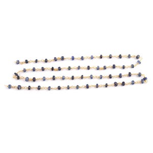 Close-up of 18K gold wire wrapping technique with natural blue sapphire bead