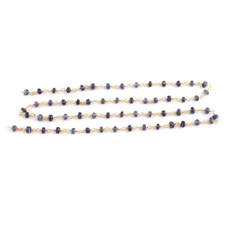 Close-up of 18K gold wire wrapping technique with natural blue sapphire bead
