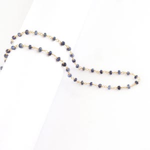 18K solid gold blue sapphire rosary chain showing natural sapphire beads wire wrapped by foot
