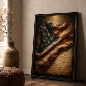 May include: A framed wall art piece featuring a weathered, textured American flag draped over a piece of aged, yellowed parchment paper with handwritten cursive script. The artwork is enclosed in a dark brown wooden frame with a deep shadow box effect.