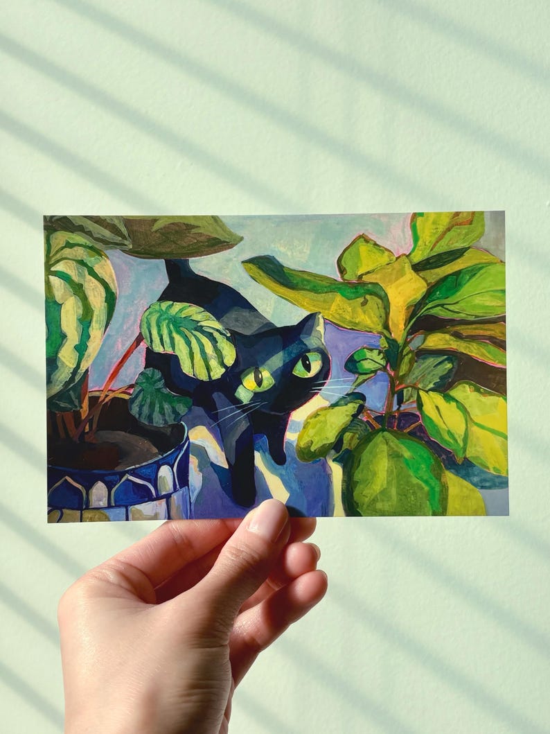 May include: A vibrant illustration featuring a black cat with striking green eyes, partially hidden amongst green and yellow foliage. The cat is positioned near potted plants in decorative blue and white pots. The artwork has a playful, artistic style.