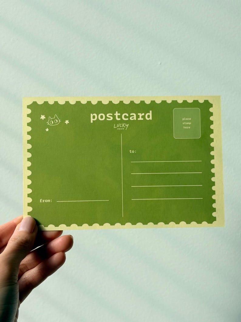 May include: A green postcard with a scalloped edge, featuring the word "postcard" and the text "Lucky". The postcard has lines for the recipient's address and a space for a stamp. A small cat illustration is in the upper left corner.