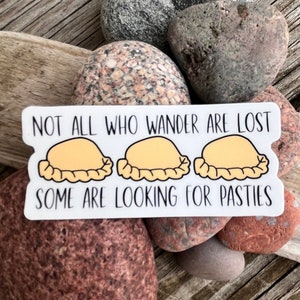 May include: White sticker with the text "Not all who wander are lost, some are looking for pasties."  Three cartoon pasties are pictured below the text.