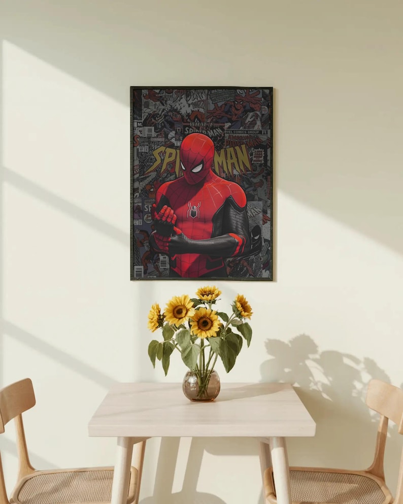 May include: A framed Spider-Man poster hangs on a wall above a small table. The poster features a red and black Spider-Man figure against a comic book background. A vase of sunflowers sits on the table.
