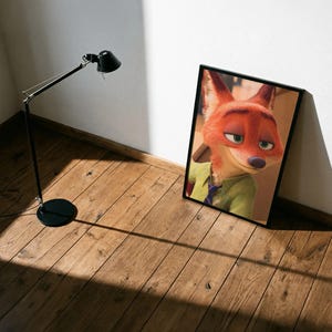 Op de afbeelding: Een ingelijste kunstdruk met het personage Nick Wilde uit de animatiefilm Zootopia. De vos heeft oranje vacht, groene ogen en een sluwe uitdrukking, draagt een groen overhemd en een paarse stropdas. De print zit in een zwarte lijst.