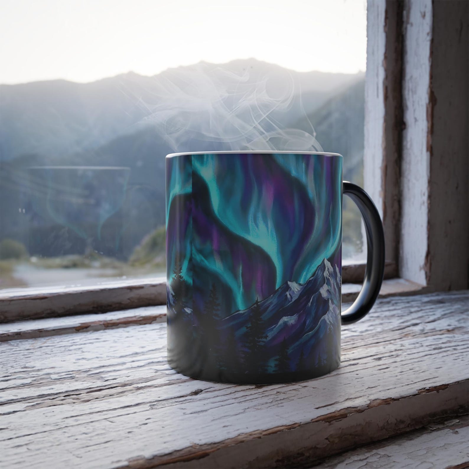 The color-changing mug on a windowsill with mountain views, aurora design fully revealed with steam rising
