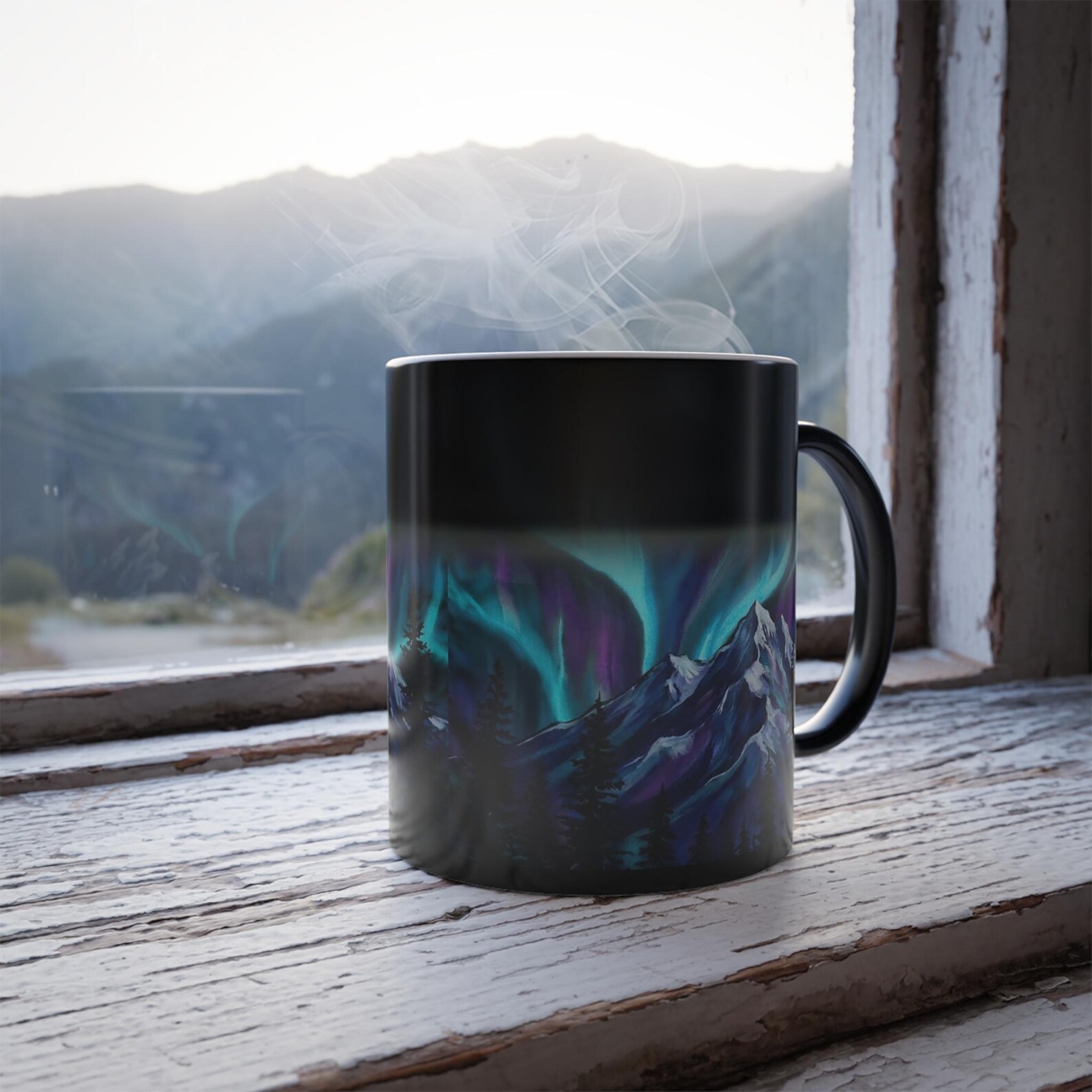The color-changing mug on a windowsill, still mid-transition with the top half black and the aurora design revealed only at the bottom