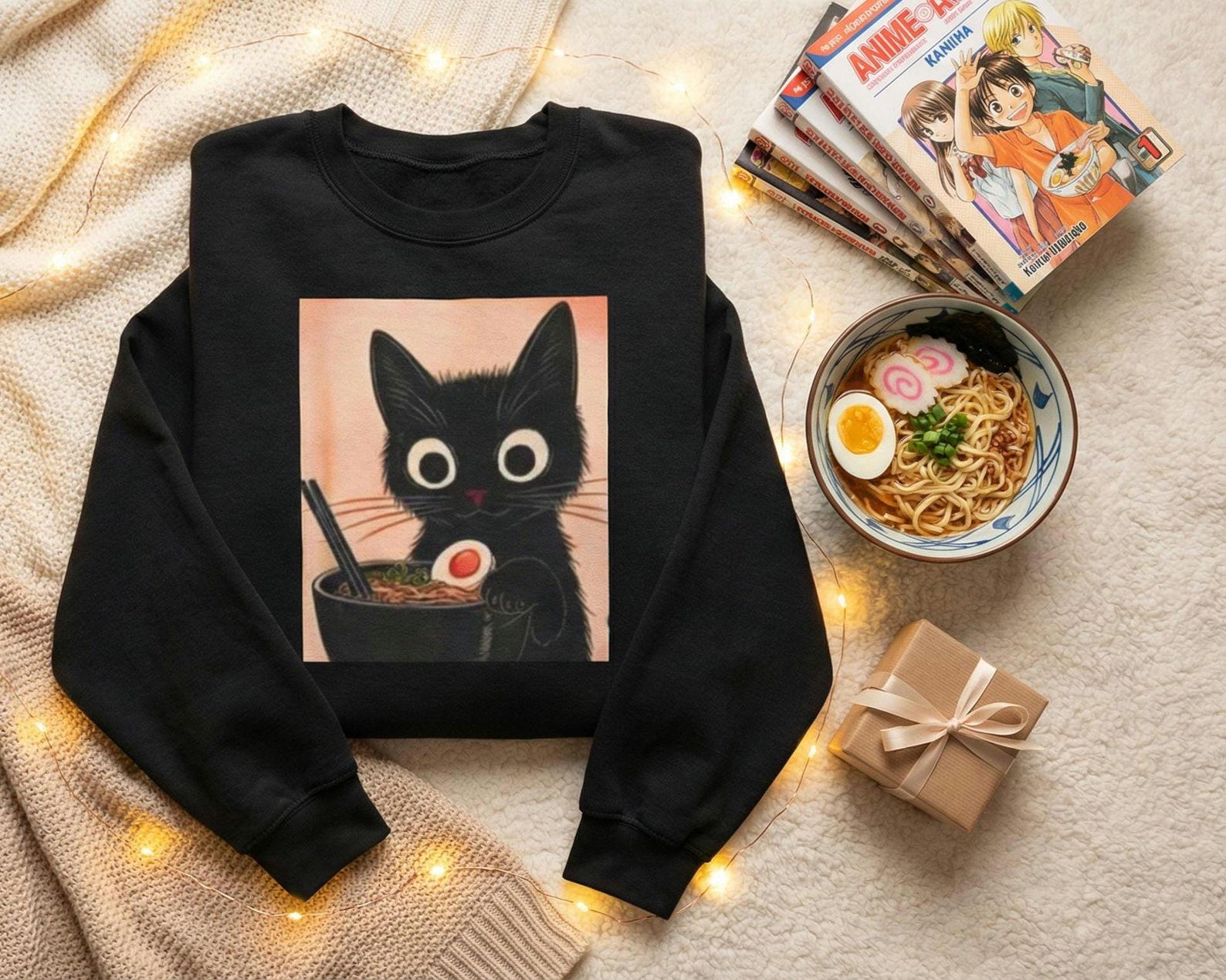 The black cat ramen sweatshirt shown in a size comparison flat lay