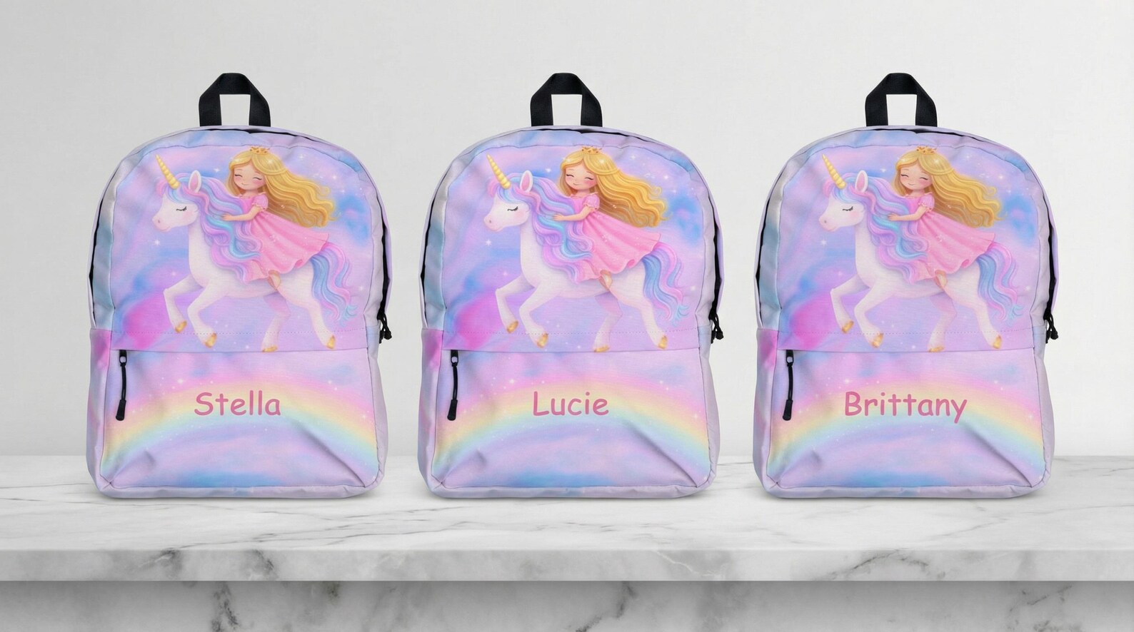 Three unicorn backpacks side by side, personalized with the names "Stella", "Lucie", and "Brittany"