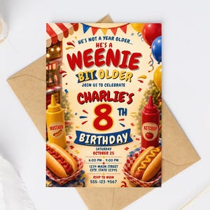 Op de afbeelding: Een verjaardagsuitnodiging met een hotdogthema in de kleuren rood, geel en blauw. De tekst luidt: He's not a year older... he's a weenie bit older, join us to celebrate Charlie's 8th birthday, zaterdag 25 oktober, 18:00 - 21:00 uur.